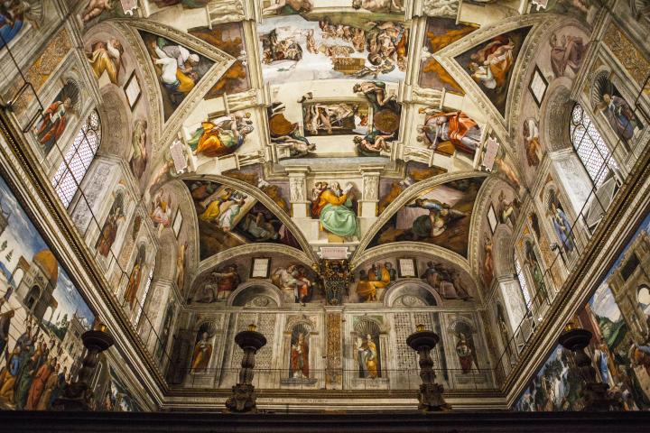 a large building with many windows with Sistine Chapel in the background