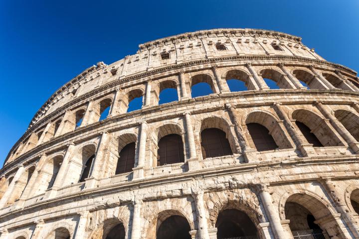 a large stone building with Colosseum in the background
