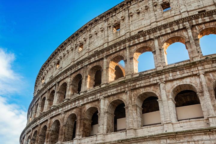 a large stone building with Colosseum in the background