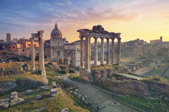 a castle on top of a grass covered field with Roman Forum in the background