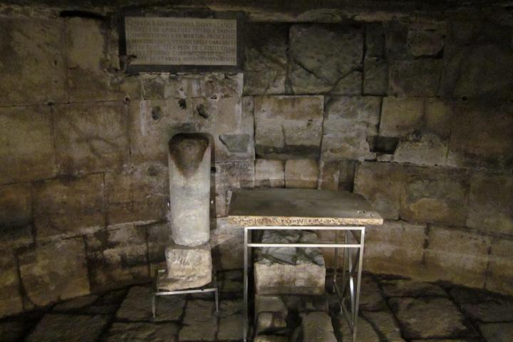 a stone bench sitting next to a brick wall