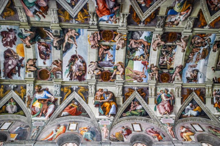 a bunch of stuffed animals on display with Sistine Chapel in the background