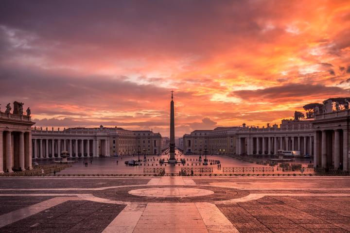 a large building with a sunset in the background