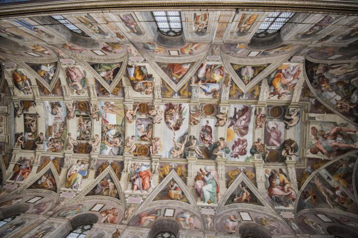 a large building with many windows with Sistine Chapel in the background