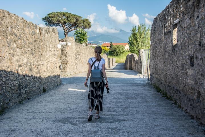 a man standing next to a stone wall