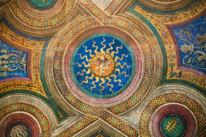 a gold and blue clock on the side of a building