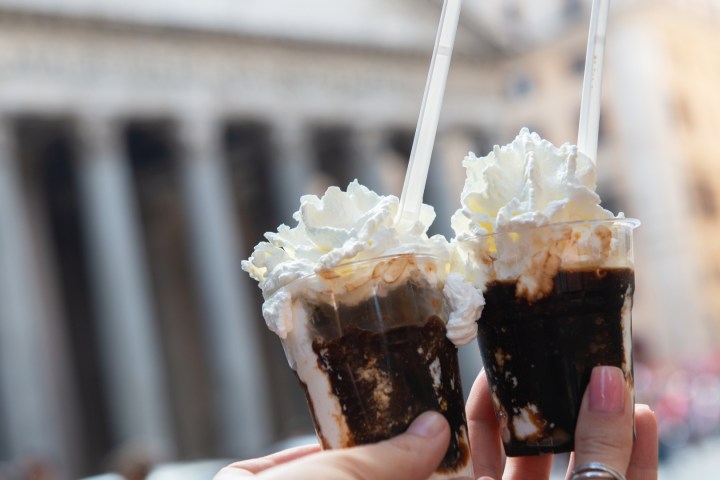 a hand holding a piece of cake