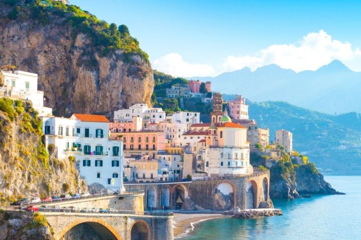 a bridge over water with a mountain in the background