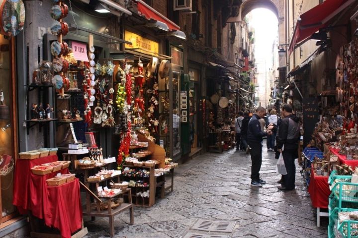 a group of people walking down the street in front of a store