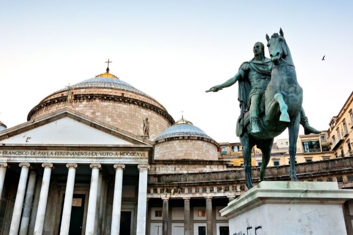 a statue of a person standing in front of a building