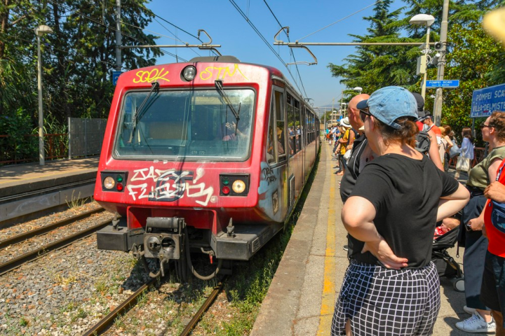 a group of people standing next to a train