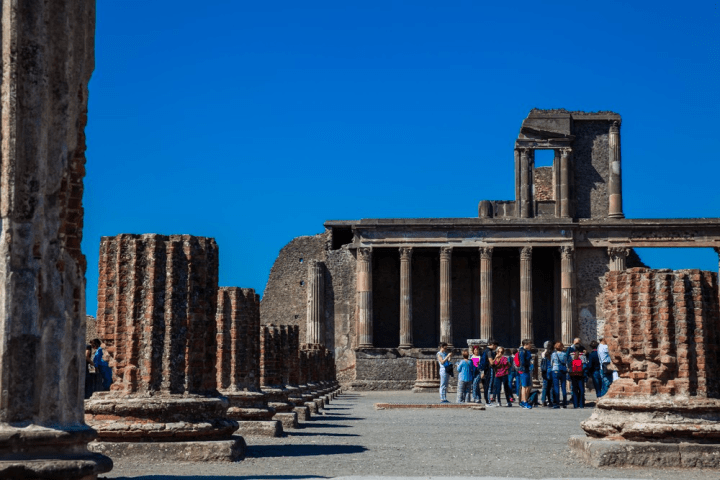 a group of people standing in front of a stone building