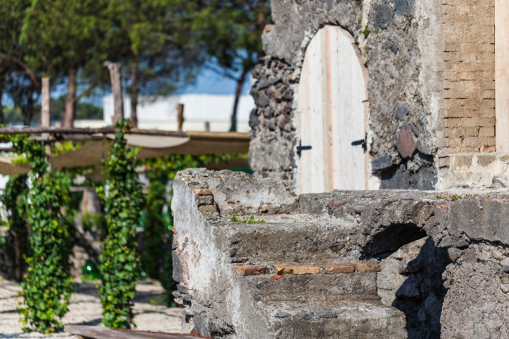 a stone building that has a bench in front of a brick wall
