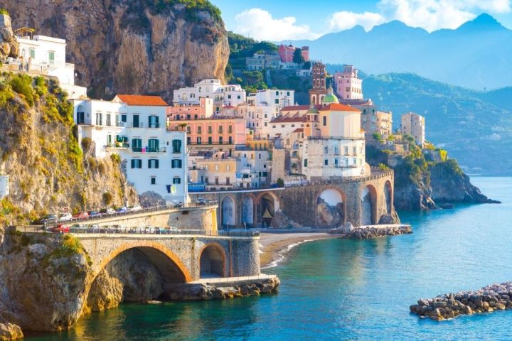 a bridge over water with a mountain in the background
