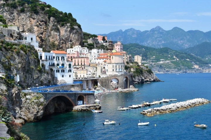 a bridge over a body of water with a mountain in the background